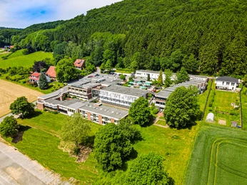 Wiehen Therme Luftaufnahme einer großen Therme umgeben von grünen Wiesen und Wäldern im Hintergrund.