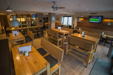 Espelkamp SportsBar (1 von 5 L) (1).jpg Helle Sportsbar mit Holzmöbeln und Fernseher, optimal für geselliges Beisammensein und Sportübertragungen.