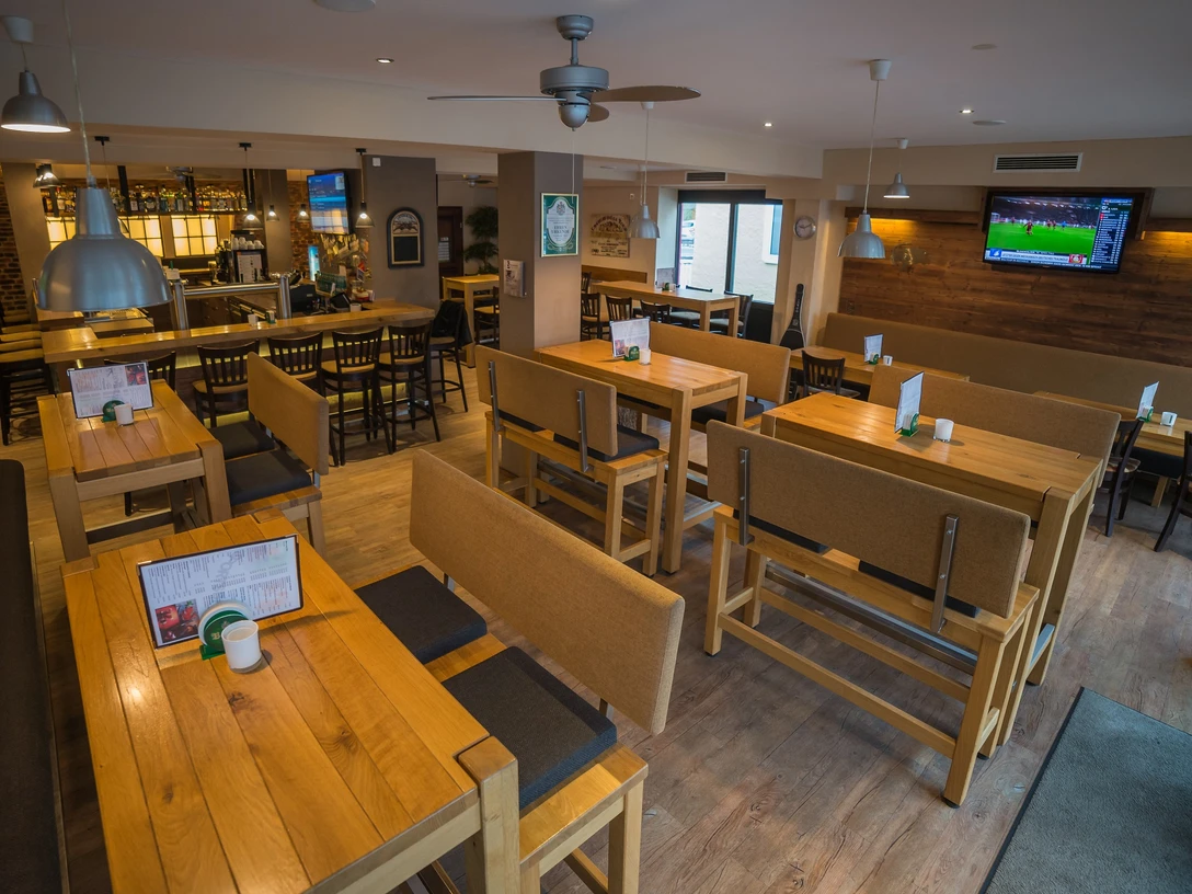 Espelkamp SportsBar (1 von 5 L) (1).jpg Helle Sportsbar mit Holzmöbeln und Fernseher, optimal für geselliges Beisammensein und Sportübertragungen.
