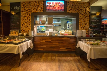 POI Schneiders am Brunnen (2 von 9) (1).jpg Restaurantbuffet mit Holzwänden, gedeckten Tischen und Einblick in die gut beleuchtete Küche.