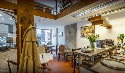 VinesCafe_Luebbecke.JPG Gemütliches Café-Interieur mit Holzelementen, antikem Dekor und Blumen auf Tischen, lädt zum Verweilen ein.