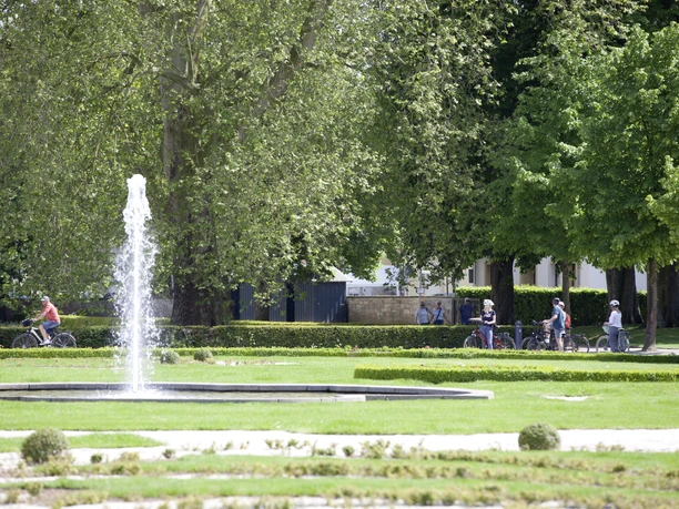 Im Schloss- und Auenpark Radfahrer genießen den großzügigen Schloss- und Auenpark mit sprudelndem Brunnen und viel Grün.