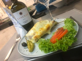 Delphi_2.jpg Ein Teller mit überbackenem Spargel, frischem Salat, Tomaten und einer Flasche KANENAS Wein.
