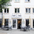 ViethThai.jpg Fassade eines vietnamesischen Restaurants "Viet Thai" mit Außensitzbereich und geöffneten Sonnenschirmen.