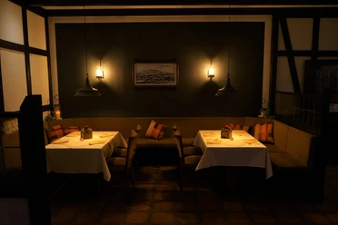 Restaurant Bonneberger Hof Ein stilvoll eingerichteter Innenbereich eines Restaurants mit sanfter Beleuchtung und gedeckten Tischen.