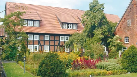 Landhotel_Marburg.jpg Fachwerkhaus mit rotem Ziegeldach, umgeben von üppigem Garten mit bunten Blumen und Sträuchern.