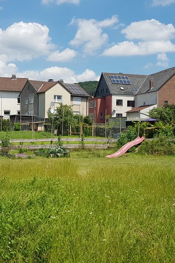 schutzhuette_georgsgarten_ottbergen_2.jpg Eine kleine hölzerne Schutzhütte im Grünen, umgeben von Häusern und einladendem Sonnenschein.