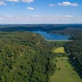 Weitläufige Wälder umgeben den Aabach-Stausee, dessen blaues Wasser die Landschaft prägt.