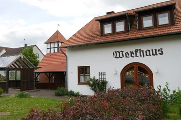 Ein traditionelles Fachwerkhaus mit roten Dachziegeln und typischer Beschriftung in ruhiger Umgebung.