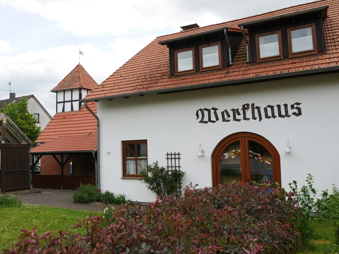 Ein traditionelles Fachwerkhaus mit roten Dachziegeln und typischer Beschriftung in ruhiger Umgebung.