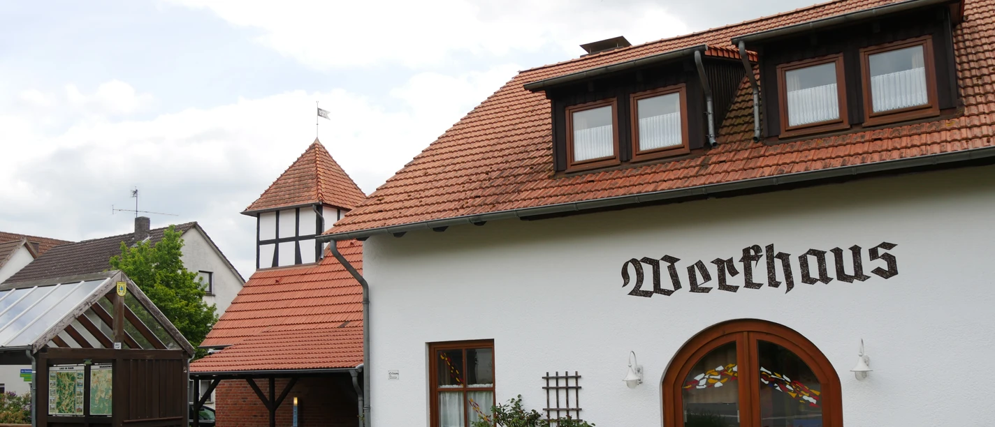 Werkhaus in Brakel-Bellersen Ein traditionelles Fachwerkhaus mit roten Dachziegeln und typischer Beschriftung in ruhiger Umgebung.