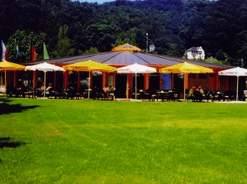 Restaurant Campingplatz Sonnenwiese Restaurant auf einem Campingplatz mit runden Dach und Außenterrasse, umgeben von grüner Wiese.