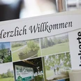 Hotel-Bad-Griepshop Menükarte mit der Aufschrift "Herzlich Willkommen" in einem Hotelrestaurant, neben einem Weißweinglas.