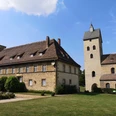 Historische Kirche St. Peter und Paul neben einem ehemaligen Kloster in einer ruhigen Landschaft.