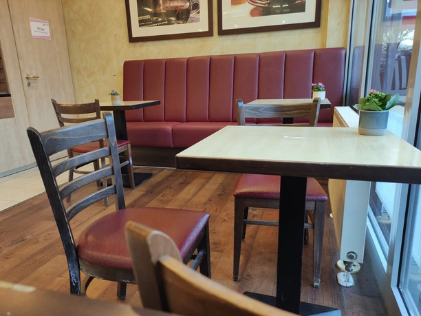 Sitzecke Brante Vlotho Eine Sitzecke in einem Café, Stühle und Bank sind mit rotem Leder bezogen, das Holz ist dunkel