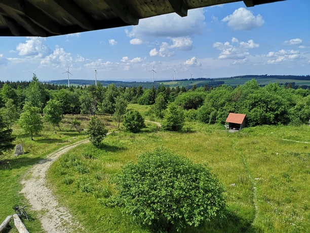 Blick vom Eggeturm Blick vom Eggeturm auf eine grüne Landschaft mit Wanderwegen, Bäumen und mehreren Windrädern am Horizont.