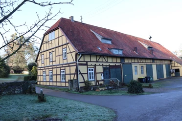 Gut Obernfelde ist ein traditionelles Fachwerkgebäude mit rotem Ziegeldach in ländlicher Umgebung.