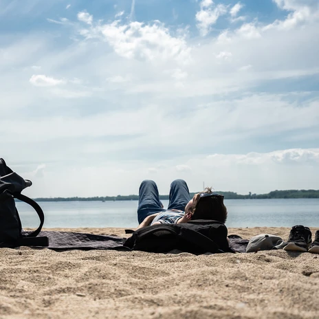 Ein junger Mann liegt am Sandstrand des Cospudener Sees mit Blick auf das Wasser und genießt die Sonne, Freizeit, Wasser, Leipziger NeuseenlandA young man lies on the sandy beach of Lake Cospuden with a view of the water and enjoys the sun, Leisure, Water, Leipziger NeuseenlandMladý muž leží na písečné pláži jezera Cospuden s výhledem na vodu a užívá si slunce, Volný čas, Voda, Leipziger NeuseenlandMłody mężczyzna leży na piaszczystej plaży nad jeziorem Cospuden z widokiem na wodę i cieszy się słońcem, Wypoczynek, Woda, Leipziger NeuseenlandEen jonge man ligt op het zandstrand van het Cospudenmeer met uitzicht op het water en geniet van de zon, Vrije tijd, Water, Leipziger NeuseenlandUn giovane si sdraia sulla spiaggia sabbiosa del lago Cospuden con vista sull'acqua e si gode il sole, Tempo libero, Acqua, Neuseenland Leipziger