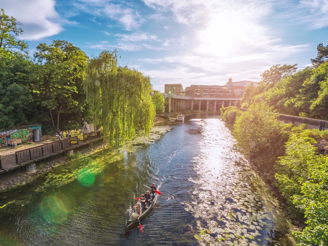 Paddler am Stelzenhaus am Karl-Heine-Kanal - Wasserwege in Leipzig Blick auf den ruhigen idyllischen Karl-Heine-Kanal im Leipziger Westen, welcher von Grün gesäumt ist und von einem Kanu und einem Ausflugsboot befahren wird, im Hintergrund das Stelzenhaus, Freizeit, Wasserwege in Leipzig, Kanu