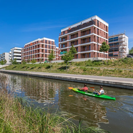 Two canoeists navigate the Lindenau harbor, which is lined with modern new buildings, Waterways in Leipzig, Green Leipzig, Boat tours, Leisure time