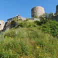 Burgruine Desenberg Ruine der mittelalterlichen Burg auf einem Hügel, umgeben von grüner Vegetation und blauem Himmel.