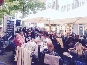 Cult1.jpg Auf dem Bild sieht man das belebte Cult an einem warmen Sommertag. Fast jeder Tisch ist besetzt.