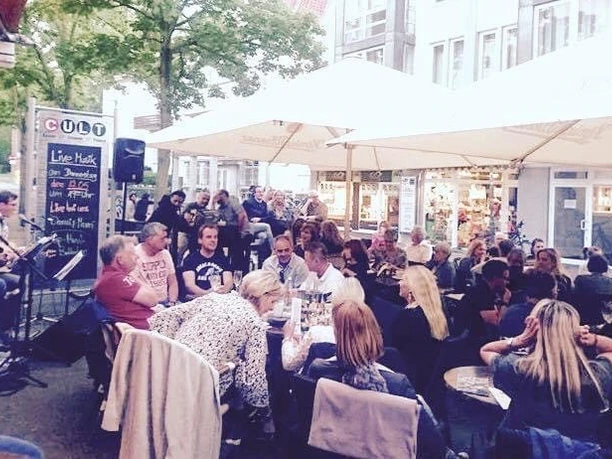 Cult1.jpg Auf dem Bild sieht man das belebte Cult an einem warmen Sommertag. Fast jeder Tisch ist besetzt.