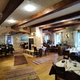 Dubrovnik Ein rustikales Restaurant mit Holzbalkendecke und Steinwänden; bunt gemusterte Teppiche zieren den Boden.