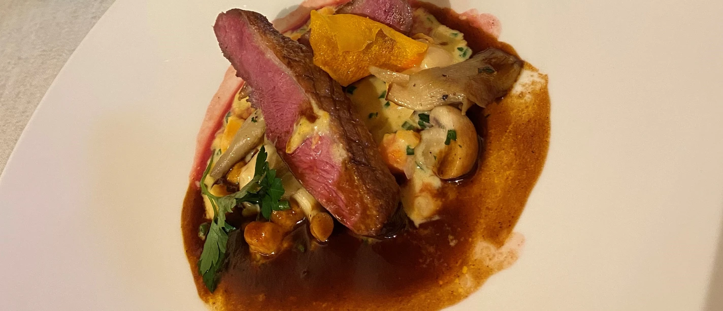 Perfectly cooked entrecôte on a savory mushroom sauce, served with a fresh herb garnish.