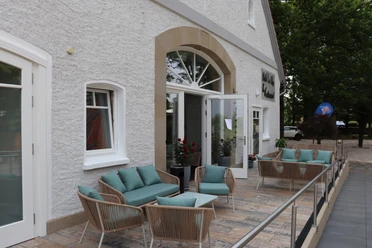 Hotel-Restaurant Lindenhof Terrasse des Hotel-Restaurant Lindenhof mit bequemen Sitzmöbeln und offenen Glastüren am Eingang.
