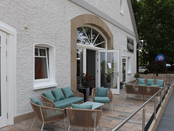 Hotel-Restaurant Lindenhof Terrasse des Hotel-Restaurant Lindenhof mit bequemen Sitzmöbeln und offenen Glastüren am Eingang.