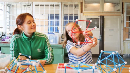 Technische Sammlungen der Stadt Dresden Zwei Mädchen bauen geometrische Strukturen aus Steckelementen in einem Workshop.