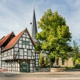 Veerhoffhaus Fachwerkhaus und Kirche im Grünen, klare Architektur, idyllischer Ort, blauer Himmel, Sonnenschein.
