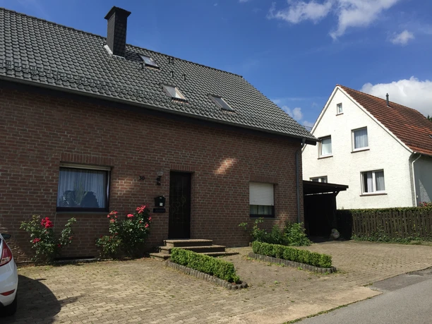 Ferienwohnungen-Dahme.JPG Zwei Einfamilienhäuser mit Satteldach, Ziegel- und Putzfassade, umgeben von Grünflächen und blauen Himmel.