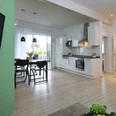 Ferienwohnung_Birke.jpg Moderne Ferienwohnung mit offener Küche, Essbereich und hellem Wohnzimmer, Parkettboden und Balkon.