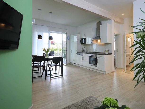 Ferienwohnung_Birke.jpg Moderne Ferienwohnung mit offener Küche, Essbereich und hellem Wohnzimmer, Parkettboden und Balkon.