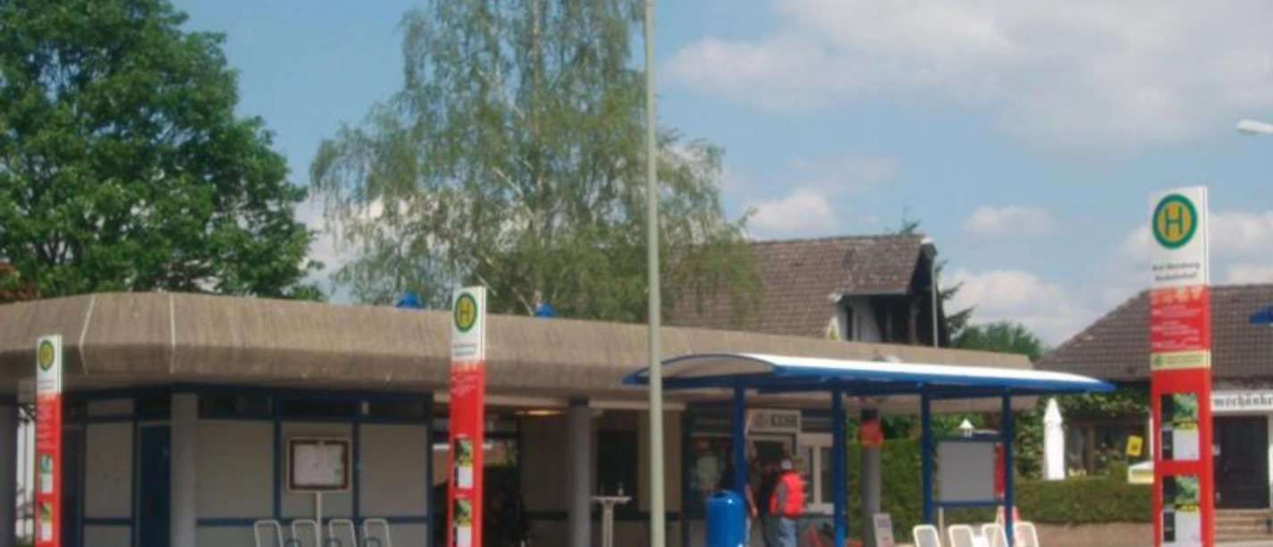 Moderner Busbahnhof mit überdachten Wartebereichen, Sitzmöglichkeiten und Haltestelleninformationen.