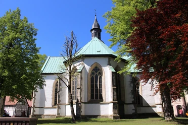 Ev. Stadtkirche Horn Evangelische Stadtkirche Horn mit gotischen Fenstern, umgeben von grünen und roten Laubbäumen.