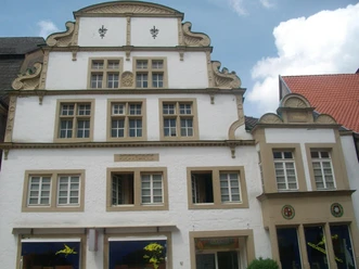 Haus Nr.71.jpg Fachwerkhaus mit dekorativen Giebeln und Sprossenfenstern, umgeben von weiteren historischen Gebäuden.
