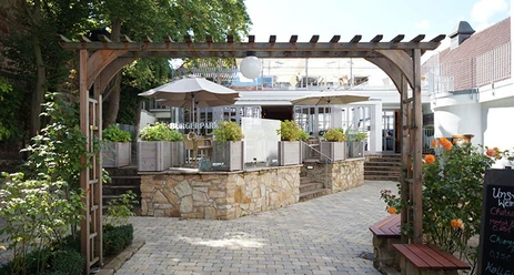 Bürgerpark Schäppchen Eingang zum Bürgerpark Schäppchen mit gemütlichem Vorplatz, Pflastersteinen und hölzernem Pergola.