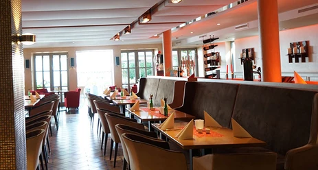 Bürgerpark Schäppchen Restaurant mit modernem Interieur, gedeckten Tischen und natürlichem Licht durch große Fenster.