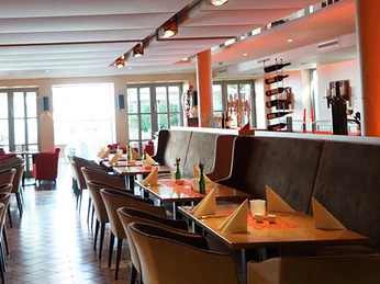 Bürgerpark Schäppchen Restaurant mit modernem Interieur, gedeckten Tischen und natürlichem Licht durch große Fenster.