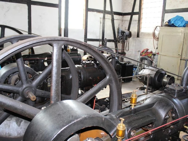 Moorpumpe Historische Maschinenanlage mit Riemenantrieb und Schwungrädern in einem Fachwerkgebäude.