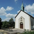 St. Josef Kapelle Feldrom St. Josef Kapelle in Feldrom mit weißer Fassade, grünem Turm und umgeben von üppigem Grün.