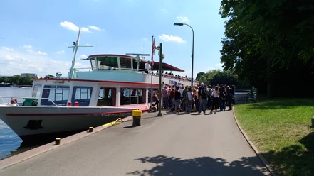 Das Bild zeigt den Anleger, an dem ein Schiff der Mindener Fahrgastschiffe liegt und Gäste einsteigen.