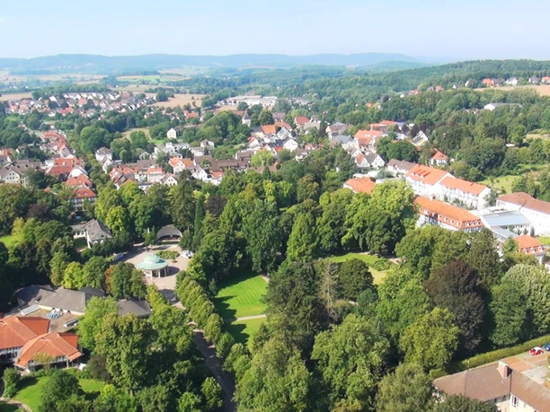 Historischer Kurpark Luftaufnahme eines historischen Kurparks mit umliegenden Gebäuden und Hügeln im Hintergrund.