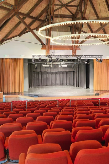 Kurtheater Bad Meinberg Sitzreihen in einem modernen Theatersaal mit hölzernem Dach und großer Bühne im Kurtheater Bad Meinberg.