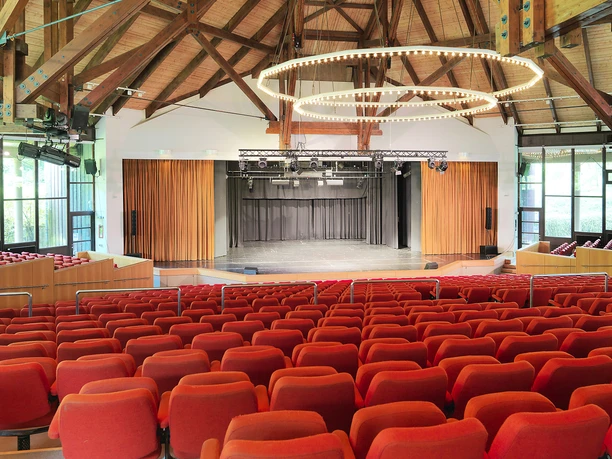 Kurtheater Bad Meinberg Sitzreihen in einem modernen Theatersaal mit hölzernem Dach und großer Bühne im Kurtheater Bad Meinberg.