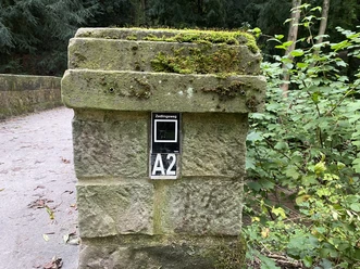 Zedlingsweg Steinbrücke mit moosbewachsenem Pfeiler des Zedlingswegs, umgeben von üppiger Waldvegetation.