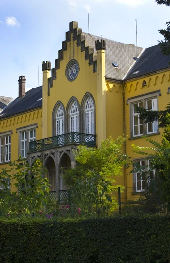 Schloss_Iggenhausen_von_vorne_01©Tourist-Information Lage.jpg Ein gelbes Herrenhaus mit stilvollen Giebeln, grüner Fassade und reich bewachsenen Gartenanlagen.